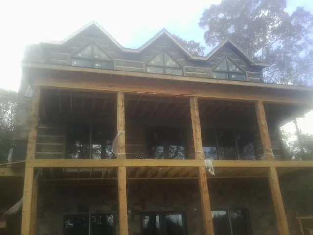 Dormers and porch framing on a large log home under construction — Roof Coating work by our crew in Ellabell