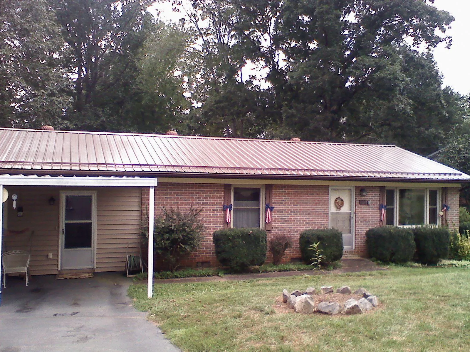 Bronze metal roof and carport on a brick ranch home — Roof Repair work by our crew in Ellabell